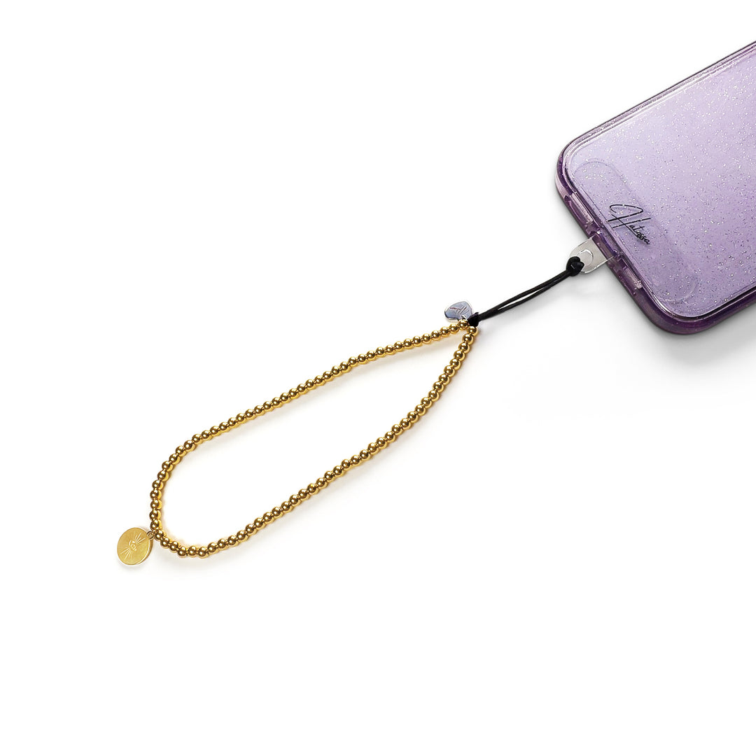 Golden Hatossa phone charm attached to a phone made of tarnish free gold beads and a sun-shaped pendant.