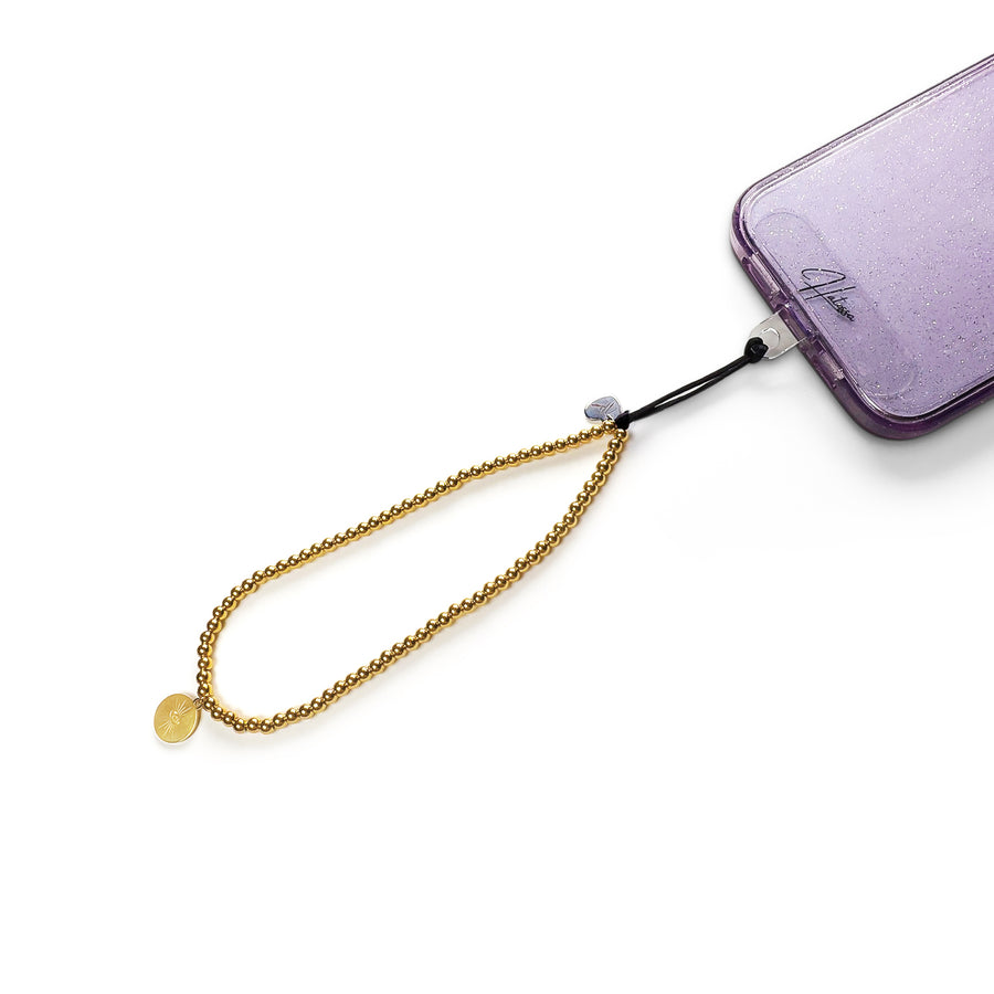 Golden Hatossa phone charm attached to a phone made of tarnish free gold beads and a sun-shaped pendant.