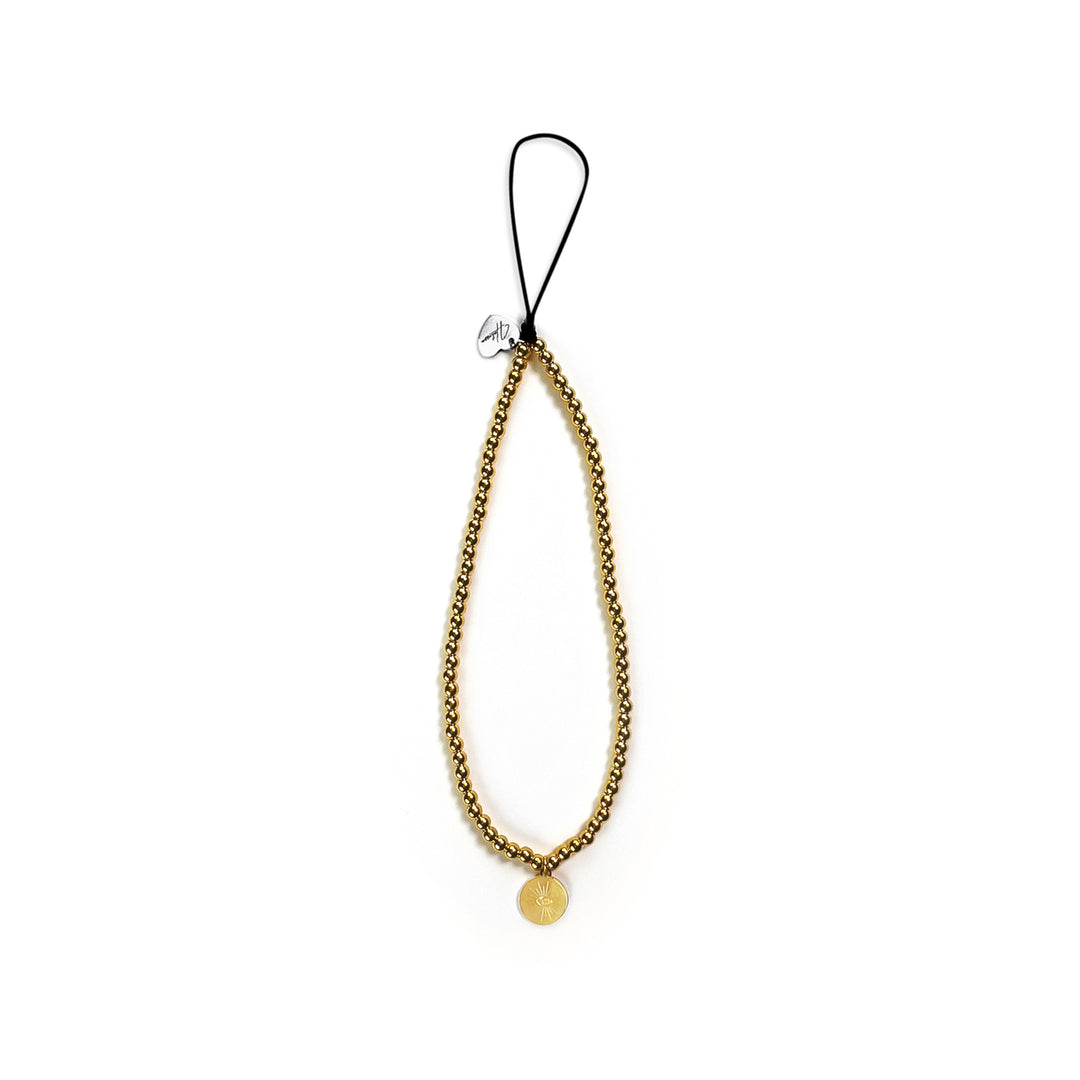Golden Hatossa Phone charm placed flat against a white background. The charm is gold, tarnish free and as a sun-shaped pendant. 