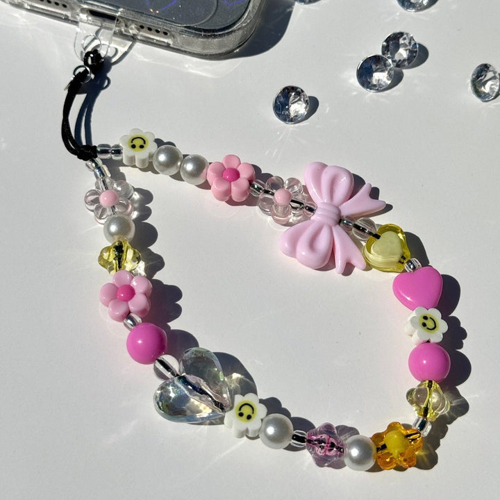 Image shows the Hatossa HONEY phone strap, phone charm, with the universal lanyard holder that can be used with any device, ebook, airpods.