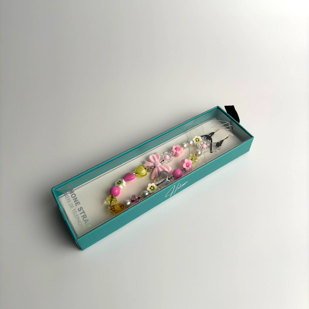 Image shows the packaged Hatossa HONEY phone strap, phone charm, with the universal lanyard holder that can be used with any device, ebook, airpods