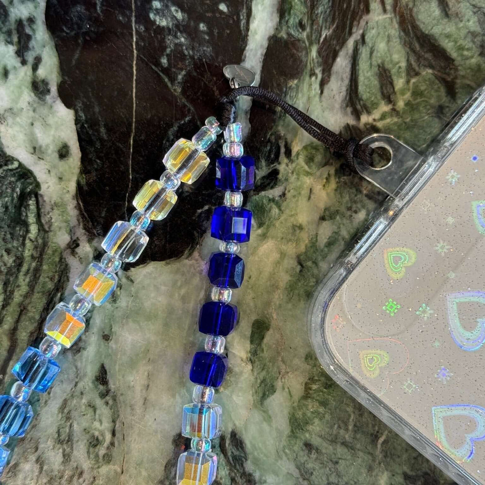 Image shows the Hatossa Mykonos phone strap, phone charm, with the universal lanyard holder that can be used with any device, ebook, airpods