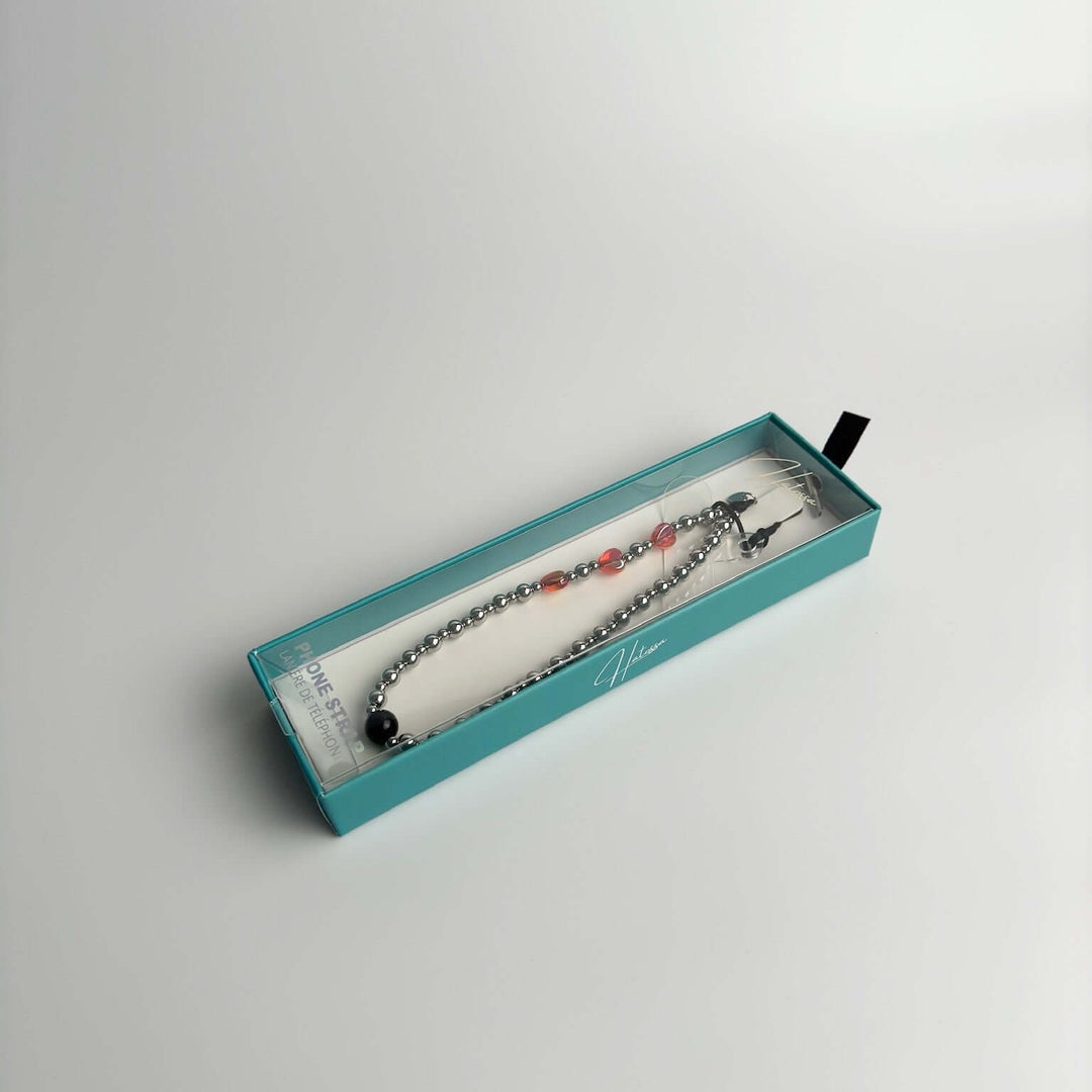 Image shows the packaging for Hatossa NOVA phone strap, phone charm, with the universal lanyard holder that can be used with any device, ebook, airpods