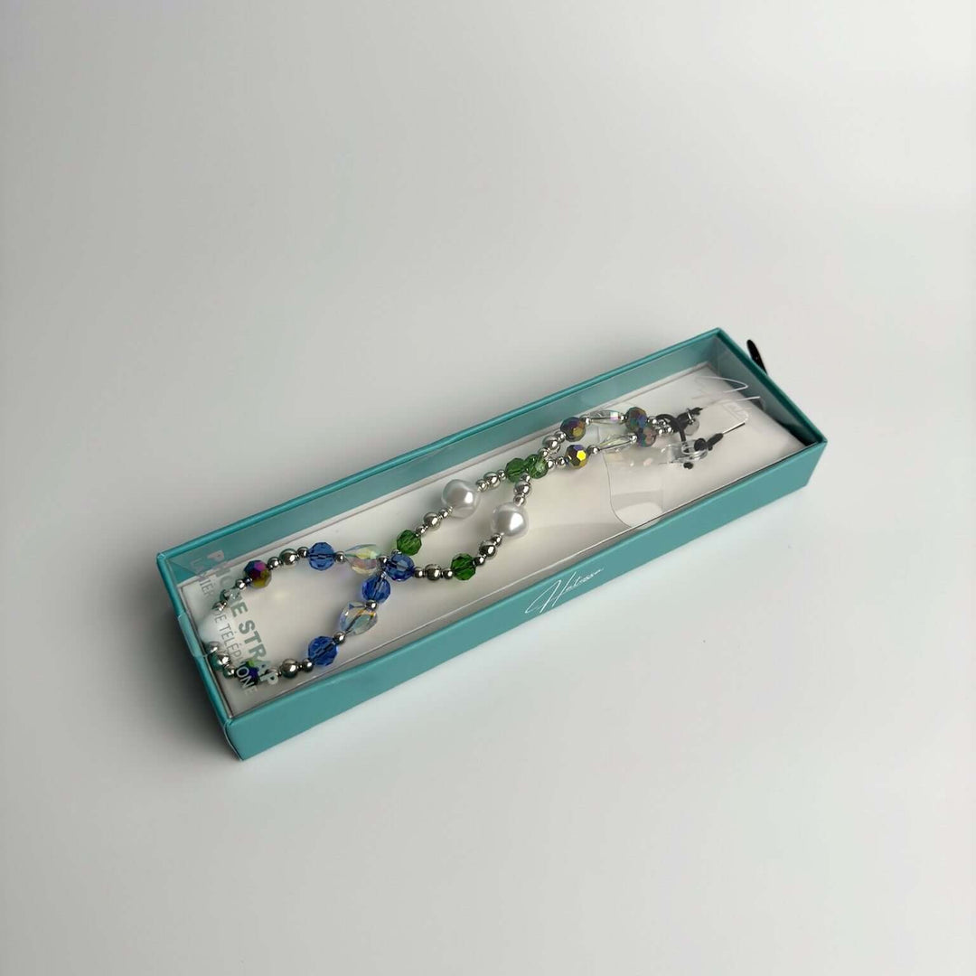Image shows the packaged Hatossa Royalty phone strap, phone charm, with the universal lanyard holder that can be used with any device, ebook, airpods