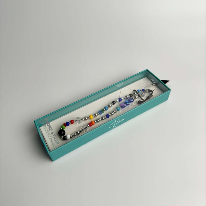 Image shows the package of Hatossa STELLA phone strap, phone charm, with the universal lanyard holder that can be used with any device, ebook, airpods