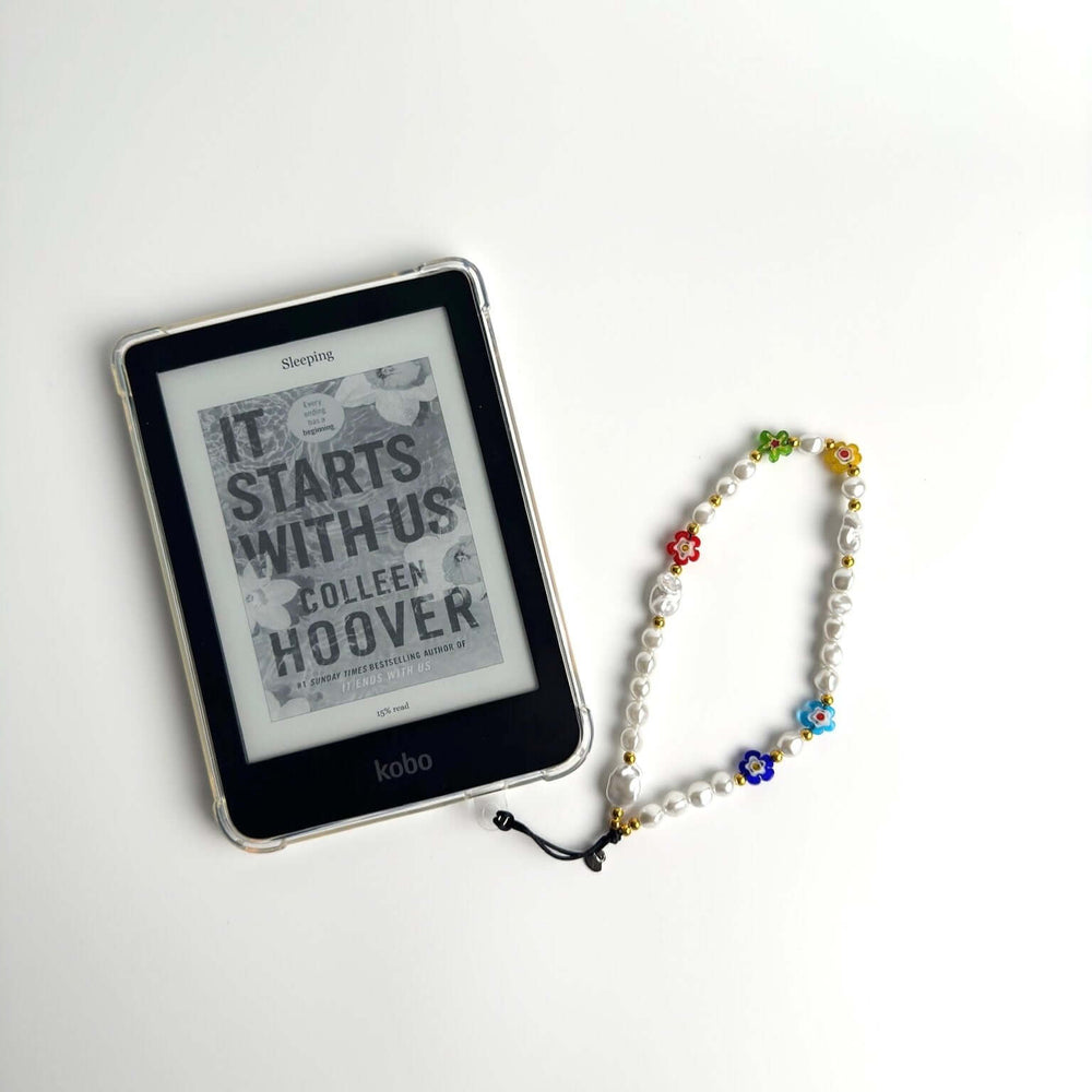 Image shows the Hatossa Summer phone strap, phone charm, with the universal lanyard holder that can be used with any device, ebook, airpods. In this case it is attached to an ebook with a case